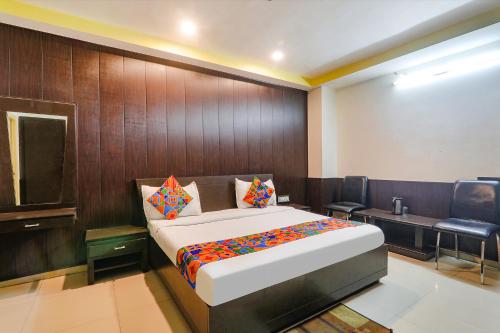 a bedroom with a bed and a chair in a room at FabHotel PS International in Lucknow