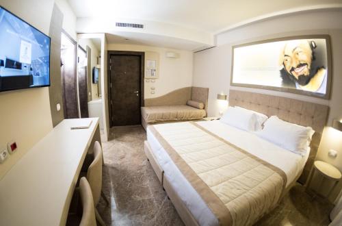 a hotel room with a bed and a flat screen tv at Best Western Premier Milano Palace Hotel in Modena