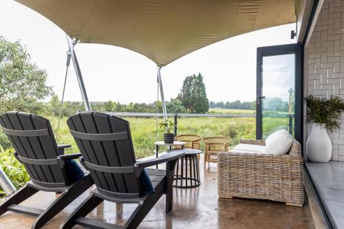 two chairs and a table on a porch with a view at Belvidere Country Estate in Karkloof Nature Reserve