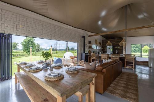 a kitchen and living room with a wooden table at Belvidere Country Estate in Karkloof Nature Reserve