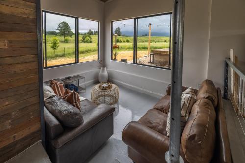 a living room with two couches and two large windows at Belvidere Country Estate in Karkloof Nature Reserve