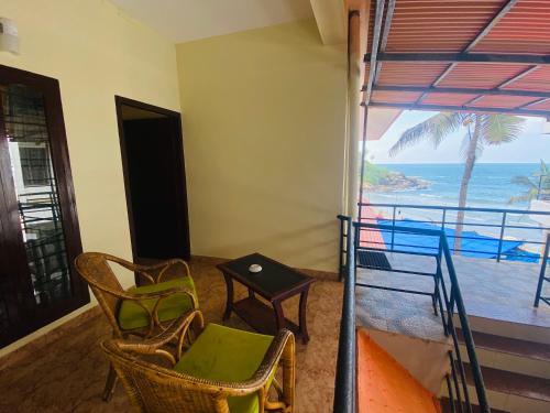 a room with a balcony with a view of the ocean at Karma Beach Resort in Kovalam