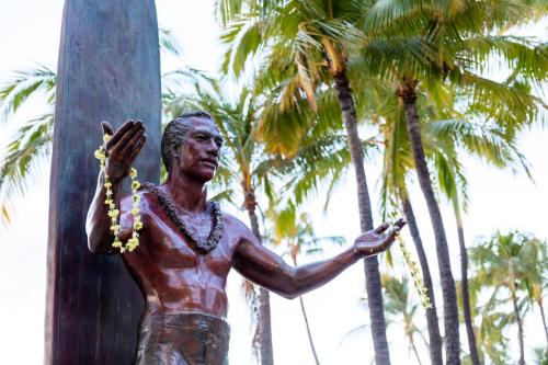 a statue of a man standing next to a pole at Wayfinder Waikiki - Voted Top 10 Best Hotels in Hawaii! in Honolulu