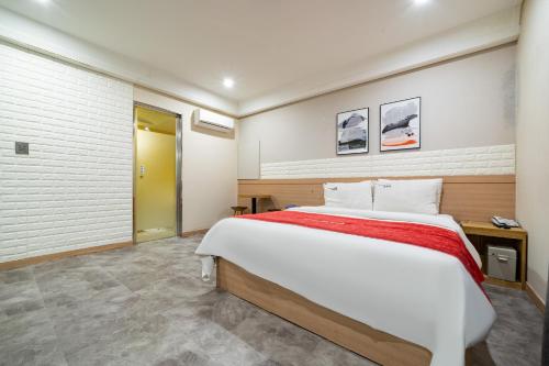 a bedroom with a large bed in a room at Boutique Hotel XYM in Suwon