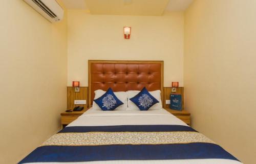 a bedroom with a large bed with blue pillows at Aster Hotel Near Mumbai Airport in Mumbai