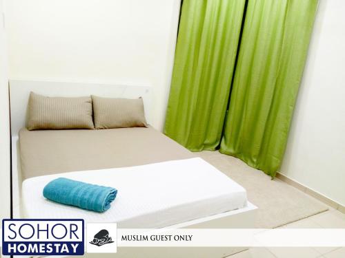 a bed in a room with a green curtain at Sohor Homestay Changlun in Changlun