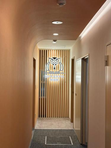 a hallway with a sign on the wall at Business Hotel Kankokukan in Tokyo
