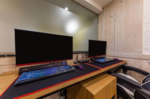 a desk with a computer monitor and a keyboard and mouse at Boutique Hotel XYM in Suwon