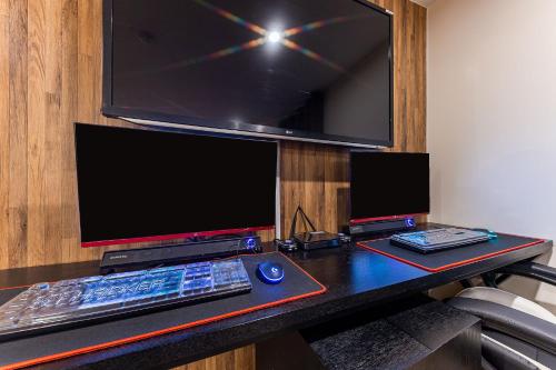 a desk with a computer monitor and a keyboard and mouse at Boutique Hotel XYM in Suwon