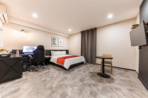 a hotel room with a bed and a desk and a computer at Boutique Hotel XYM in Suwon