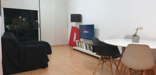a room with a table and chairs and a tv at LINA'S HOME & POOL - Breakbooking CY in Laxia