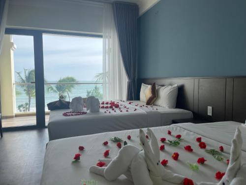 a hotel room with two beds with roses on them at Hon Rom 2 Resort in Mui Ne