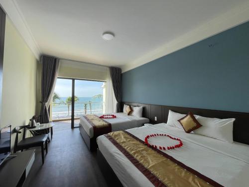 a hotel room with two beds and a large window at Hon Rom 2 Resort in Mui Ne