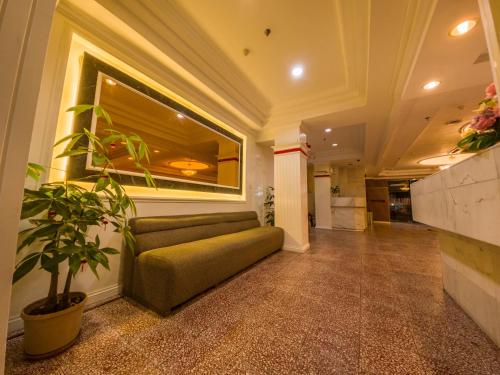 a living room with a couch and a plant at Miri Hotel in Miri