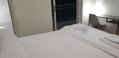 a white bed in a room with a mirror at LINA'S HOME & POOL - Breakbooking CY in Laxia