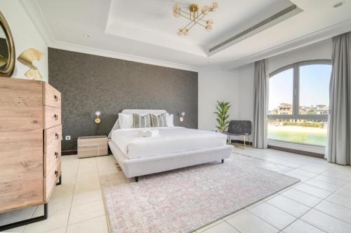 a bedroom with a white bed and a large window at Stella Stays Brilliant 4 BDR Palm Villa Beach Private Pool in Dubai