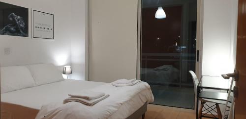 a bedroom with a white bed and a chair at LINA'S HOME & POOL - Breakbooking CY in Laxia