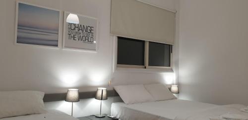 a white bedroom with two beds and two windows at LINA'S HOME & POOL - Breakbooking CY in Laxia