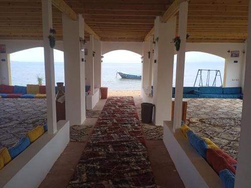 a hallway with a view of the water and a boat at Abo Hamada Azure Camp in Nuweiba