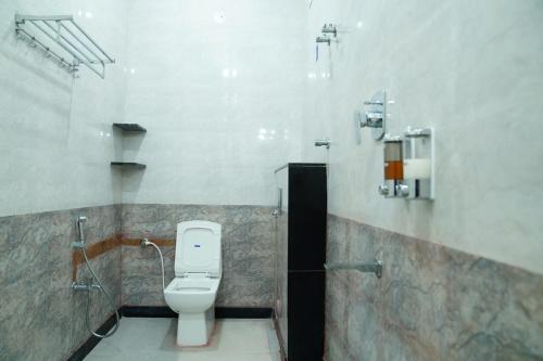 a bathroom with a white toilet in a stall at Kantesha Nest in Shimoga