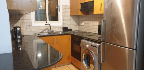 a kitchen with a stainless steel refrigerator and a dishwasher at LINA'S HOME & POOL - Breakbooking CY in Laxia