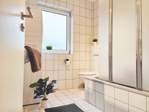 La salle de bains est pourvue de toilettes et d'une fenêtre. dans l'établissement Chic Apartments in Altenstadt, à Altenstadt