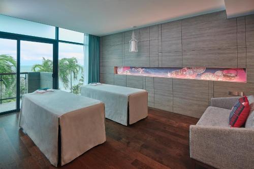 a living room with two beds and a couch at Angsana Teluk Bahang, Penang in Batu Ferringhi