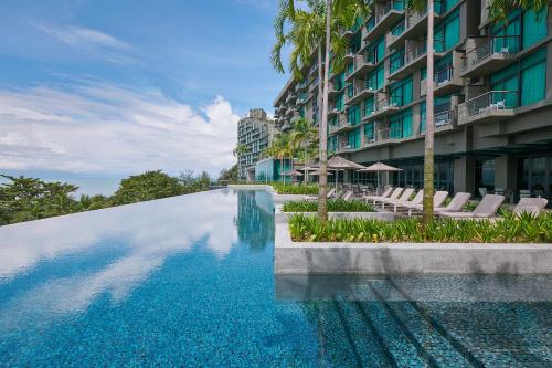 a swimming pool in front of a building at Angsana Teluk Bahang, Penang in Batu Ferringhi