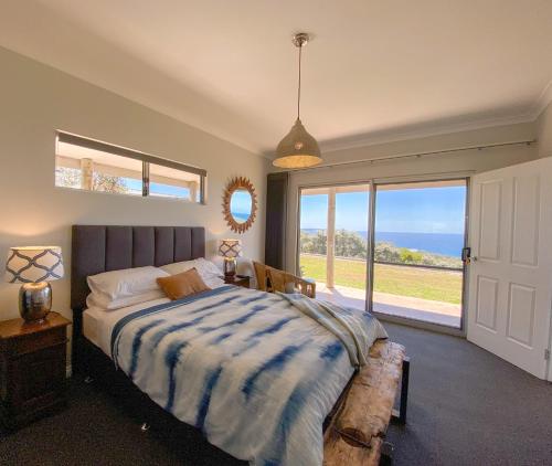 a bedroom with a bed and a large window at Bremer Bay B&B in Bremer Bay