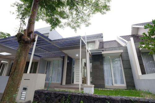 ein Haus mit einem Baum davor in der Unterkunft Villa Brassia - 3 Bedrooms 