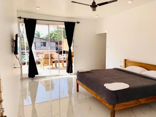 a bedroom with a bed and a large window at Crystall Goa, Onyx Edition in Palolem