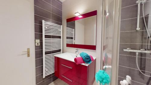 ein Bad mit einem roten Waschbecken und einer Dusche in der Unterkunft Face au Port de SAINT GILLES CROIX DE VIE in Saint-Gilles-Croix-de-Vie