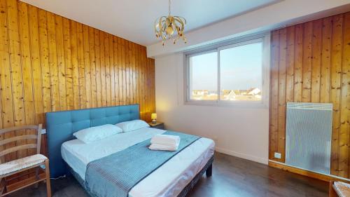 ein Schlafzimmer mit einem blauen Bett und einem Fenster in der Unterkunft Face au Port de SAINT GILLES CROIX DE VIE in Saint-Gilles-Croix-de-Vie