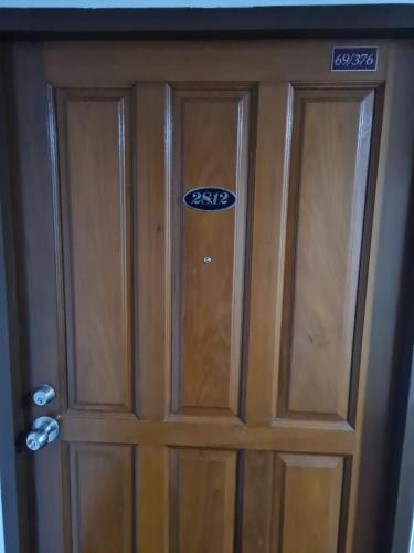 a wooden door with a sign on it at Omni Tower 2 Bed Room Sukhumbit Best Apartment in Bang Kapi
