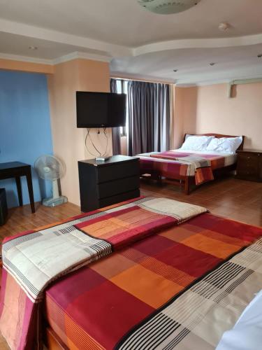 a hotel room with two beds and a flat screen tv at Omni Tower 2 Bed Room Sukhumbit Best Apartment in Bang Kapi