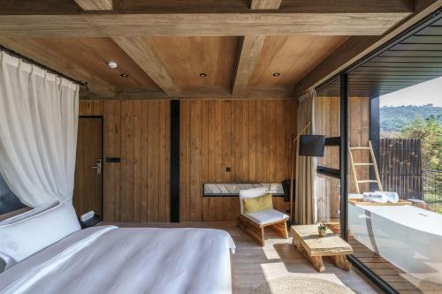 a bedroom with a bed and a tub and a window at Deer Chaser Hotel in Yuchi