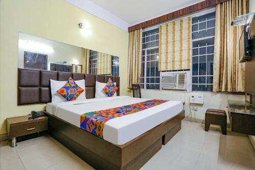 a bedroom with a large bed and a desk at FabExpress Kanha Classic in Kānpur
