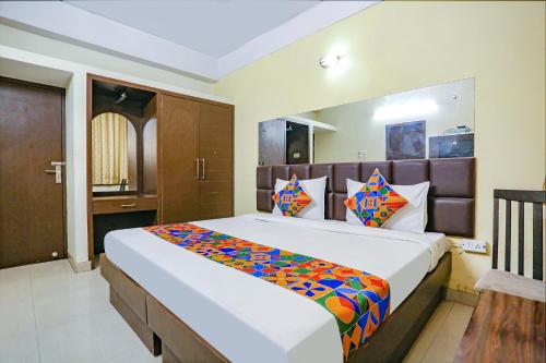ein Schlafzimmer mit einem großen Bett in einem Zimmer in der Unterkunft FabExpress Kanha Classic in Kānpur