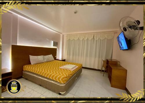 um quarto com uma cama e uma televisão em White Knights Real em Dumaguete