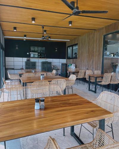 a dining room with wooden tables and chairs at Gunita Villas in Santo Tomas