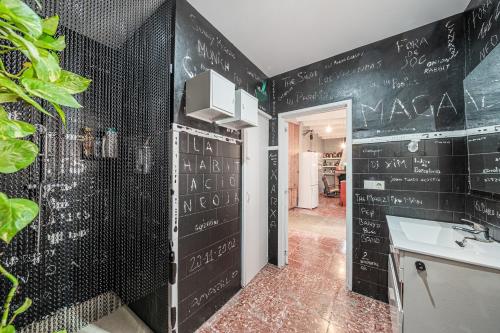 a kitchen with a black wall with writing on it at Townhouse Can Miquel in Sa Pobla