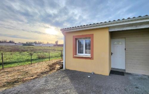 une maison avec une fenêtre sur le côté de celle-ci dans l'établissement Logement thermale et de tourisme Les Acacias 6, à Jonzac