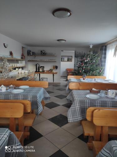 a restaurant with tables and a christmas tree in it at Pokoje u Matusa in Gliczarów