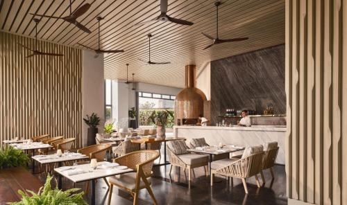 a restaurant with tables and chairs and a bar at Chatrium Grand Bangkok in Bangkok