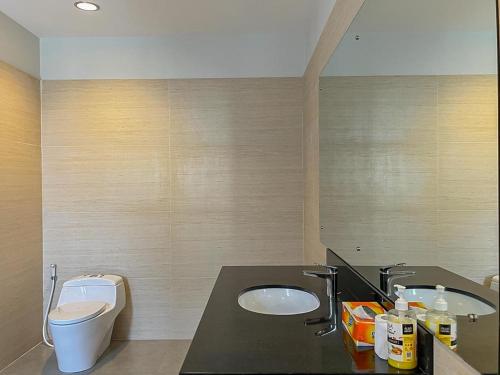 a bathroom with a sink and a toilet at Merbau Luxurious Villa Senggigi by The Lavana - 5 Bedroom Villa in Mataram