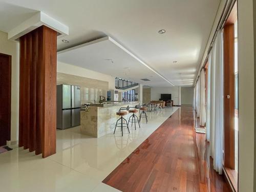 a large kitchen and dining room with wooden floors at Merbau Luxurious Villa Senggigi by The Lavana - 5 Bedroom Villa in Mataram