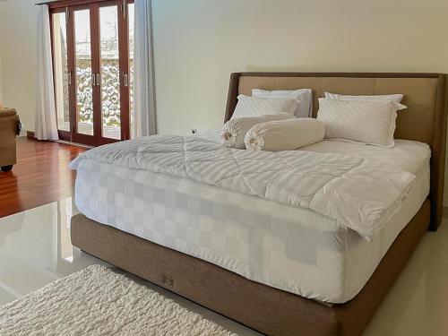 a bed with white sheets and pillows in a bedroom at Merbau Luxurious Villa Senggigi by The Lavana - 5 Bedroom Villa in Mataram