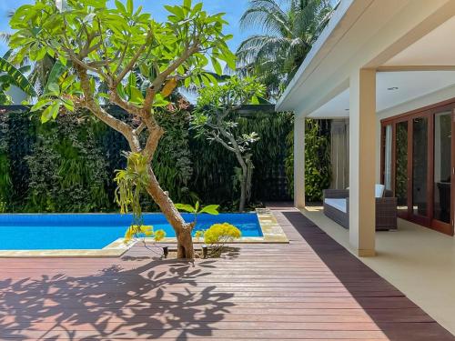 an external view of a house with a tree in the yard at Merbau Luxurious Villa Senggigi by The Lavana - 5 Bedroom Villa in Mataram