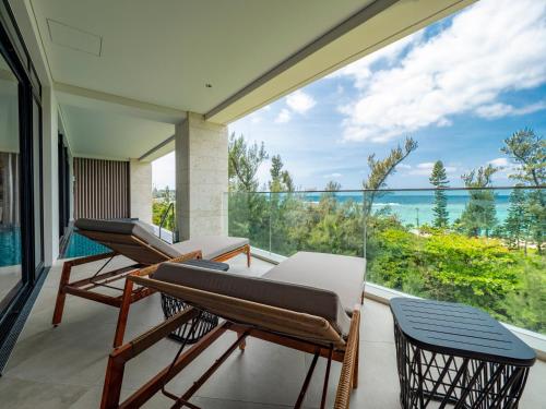 a balcony with chairs and a view of the ocean at UMITO Okinawa Onnason in Onna