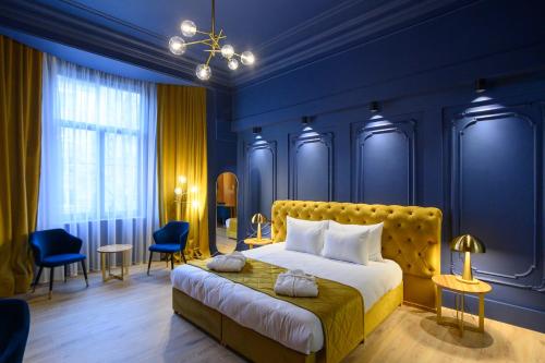 1 dormitorio con 1 cama grande y paredes azules en HOTEL VIENA, en Satu Mare